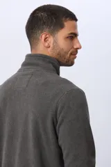 Campera gris de polar texturado liviano, con cuello alto, cierre frontal y bolsillos laterales con cierre.