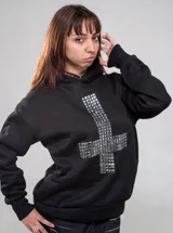Buzo canguro negro con capucha, corte regular fit, de manga larga, con gran diseño de cruz frontal elaborado con tachas metálicas plateadas y tachas en el borde de la capucha.