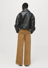 Pantalón wide leg de tiro bajo confeccionado en tejido de pana color tostado, con bolsillos laterales y bolsillos de ribete en la parte posterior.