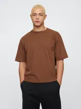 Remera color beige de corte holgado y mangas cortas.