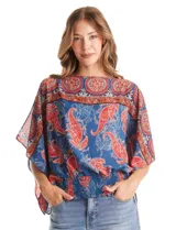Blusa de gasa con estampado de arabescos en tonos azules y rojos, con cuello a la base y mangas tipo capa. Presenta una silueta holgada con ruedo elástico en punto smock que ajusta a la cintura.