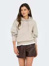 Canguro de abrigo color beige, con capucha ajustable mediante cordón, bolsillo tipo canguro en el frente, mangas largas y puños y cintura de rib elástico.