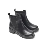 Bota corta negra de estilo urbano clásico, con paneles laterales elastizados de textura tramada y cierre interno. Tiene una tira trasera para facilitar el calce, punta redondeada y suela de goma con relieve antideslizante.