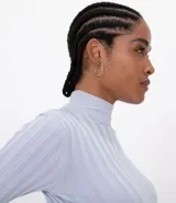 Polera color camel de punto acanalado, con cuello alto y mangas largas.