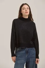 Sweater de punto negro con cuello alto y diseño de puntos brillantes en contraste. Presenta mangas largas con puños ajustados y un corte recto a la cintura.