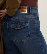 Pantalón de jeans azul, modelo flare con caída ajustada y bolsillos traseros con solapa.