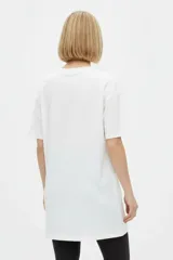 Remera blanca de algodón con cuello redondo, mangas cortas y calce holgado. Cuenta con un estampado frontal de estilo gráfico que dice "Negroni" junto con la ilustración de un trago y rodajas de naranja.