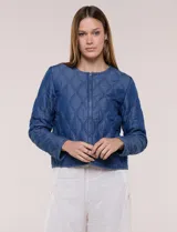 Campera corta azul de lyocell con acabado matelaseado en patrón de ondas, escote redondo, cierre frontal con cremallera y manga larga.