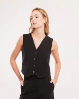 Chaleco de vestir gris oscuro con textura tipo tweed, escote en V y botones frontales. Corte levemente entallado y largo a la cintura.