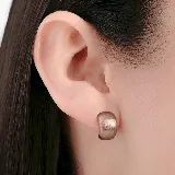 Aros tipo argolla pequeña de diseño ancho y superficie texturizada con acabado mate en tono dorado.