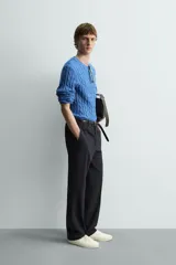 Jersey de punto de algodón, color azul, con cuello redondo y manga larga. Presenta un tejido con estructura de trenzas verticales a lo largo de todo el cuerpo y mangas.