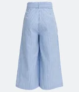 Pantalón pantacourt a rayas verticales azules y blancas, confeccionado en algodón. Incluye cinturón blanco con hebilla forrada.