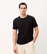 Remera de algodón peruano color negro, de manga corta y cuello redondo con reborde blanco al igual que los puños. Presenta textura en rayas verticales.
