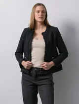 Chaqueta negra en tejido tweed de la marca Nanette. Tiene escote mao, abertura central y bolsillos delanteros. Los puños tienen apliques de botones perlados y la terminación es desflecada. Tiene forro interno.