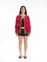 Campera tejida en jacquard con cierre frontal, cuello tipo polo y bolsillos delanteros. Diseño multicolor con estampado geométrico de rombos y detalles bordados a mano.