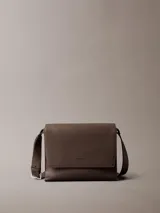 Cartera tipo mensajero con solapa y cierre magnético, confeccionada en piel sintética texturizada (micro pebble). Presenta correa ajustable y múltiples bolsillos interiores.