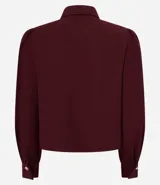 Camisa celeste de crepé con cuello inglés, manga larga abullonada y abotonadura frontal.