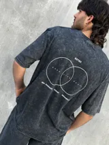 Remera gris con efecto lavado, corte oversize, manga corta y estampado pequeño en el frente.