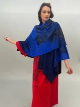 Ruana de lana merino tejida, teñida y estampada, con cuello plisado en fieltro de lana merino.