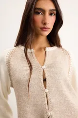 Saco de algodón tejido, color beige con mangas y detalles en blanco, escote en V y cierre frontal de botones.