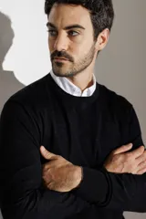 Sweater azul marino de lana merino, con cuello redondo y mangas largas. Tejido de punto liso. Corte clásico.