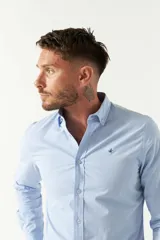 Camisa celeste de algodón con corte slim fit y logo bordado en el pecho.