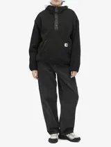 Campera de fleece texturizado color negro, con cuello alto, cierre frontal parcial con botones a presión y bolsillo tipo canguro. Presenta detalles en tafeta de nylon y etiqueta tejida de la marca en el frente.