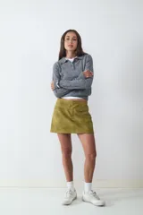 Suéter tejido de punto color gris, con cuello polo y escote en V con un botón. Tiene mangas largas y está confeccionado en un tejido suave y liviano.