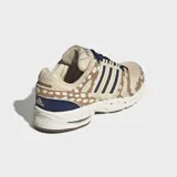 Championes Adidas Adistar Control 5 con diseño retro inspirado en los años 2000. Presenta parte superior de malla transpirable color beige con estampado animal print de leopardo, capas superpuestas de cuero peludo, las tres tiras características de la marca en azul marino y cordones oscuros.