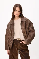 Campera de cuero marrón con mangas desmontables, permitiendo su uso como chaleco. Presenta cuello camisero, cierre frontal y diseño versátil.