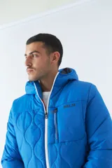 Campera de nylon negra con capucha, cierre frontal con cremallera, bolsillos laterales con cierre y logo de goma en el pecho.