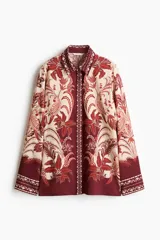 Camisa de viscosa con diseño estampado, corte oversized, cuello clásico, botones ocultos en la parte delantera y mangas largas.