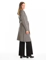 Chaqueta larga de tejido de punto con estampado de pata de gallo en blanco y negro. Presenta cuello de solapa, cierre frontal con lazo ajustable en la cintura y bolsillos aplicados en el frente.