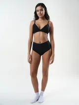 Bralette de algodón rib, color beige, de diseño triangular sin aro, con tirantes finos regulables y banda elástica bajo el busto con la marca grabada.