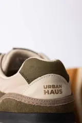 Championes urbanos Urban Haus modelo Julen, con diseño de paneles en tonos verde oliva y beige. Presentan una combinación de texturas en gamuza y material sintético, con suela de goma dentada en color caramelo.