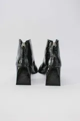 Botinetas de cuero charolado color negro, con taco cuadrado de 6,5 cm, punta cuadrada y diseño de corte en V en el empeine.