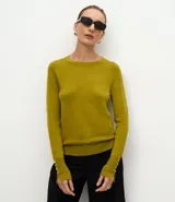 Suéter de punto ajustado con cuello redondo y manga larga. Presenta detalle de botones metalizados en los puños.