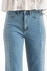 Jean de corte recto y tiro medio, confeccionado en denim de algodón con un toque de elastano. Presenta costuras verticales decorativas a lo largo de las piernas y un ruedo deshilachado.