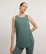 Musculosa deportiva de poliamida color verde, con escote redondo, sisas amplias y diseño holgado. Presenta un recorte horizontal en la espalda con un leve pliegue central para mayor libertad de movimiento.