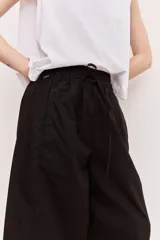Pantalón negro de tiro alto con cintura elastizada y cordón ajustable, de corte amplio y relajado, con bolsillos laterales.