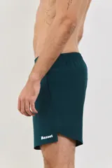 Short deportivo de hombre, confeccionado en tejido liviano y respirable con spandex para mayor movilidad. Presenta cintura elástica de 4 cm, bolsillos laterales y logo de la marca estampado en el ruedo. Diseño de largo medio con aberturas laterales.