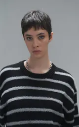 Sweater de cuello redondo con diseño de rayas horizontales en negro y gris. Presenta una textura suave y peluda, con terminaciones en punto rib en el cuello.