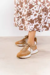 Zapatillas deportivas color blanco con detalles en beige y suela marrón.