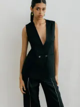 Chaleco sastrero negro de lino, con cuello en V profundo y cierre cruzado con botones.