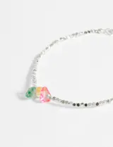 Pulsera plateada de cuentas metálicas facetadas, con dijes colgantes de piedras en tonos verde, amarillo y rosado.