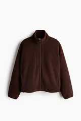 Campera deportiva de sherpa marrón con cuello elevado, cierre frontal y bolsillos laterales.
