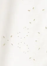 Jeans blancos de silueta balloon, tiro regular y largo standard, con detalles bordados sutiles en las perneras.