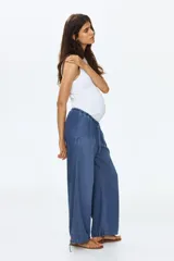 Pantalón de denim suave color azul, de corte holgado estilo globo con piernas abombadas, cintura elastizada con cordón ajustable y bajos con elástico y cintas para ajustar.