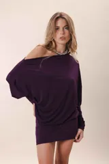 Vestido corto color gris oscuro, con escote asimétrico dejando un hombro al descubierto, mangas largas y corte holgado.