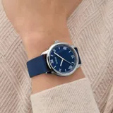 Reloj analógico Guess Easton con caja de acero inoxidable, esfera azul con números romanos y correa de silicona azul.
